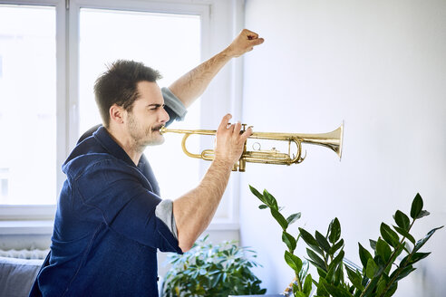 Mann zu Hause spielt Trompete - BSZF00392