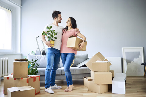 Glückliches Paar beim Auspacken in der neuen Wohnung, lizenzfreies Stockfoto