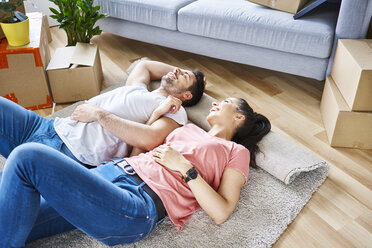 Happy couple relaxing while moving into new apartment - BSZF00412