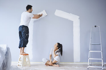 Paar malt Hausform auf Wand in neuer Wohnung - BSZF00418