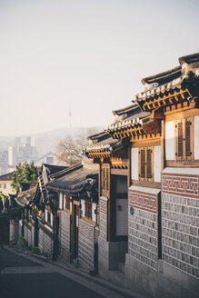 Südkorea, Bukchon Hanok Dorf, Straße mit traditionellen Häusern, Seoul Tower im Hintergrund - GEMF01987
