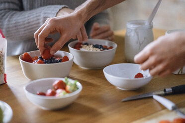 Hands of young couple preparing fruit breakfast at kitchen counter - CUF06838