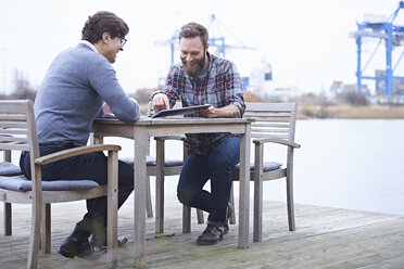 Zwei männliche Designer treffen sich vor dem Designstudio am Wasser - CUF06918