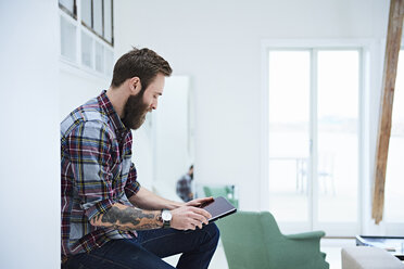 Young male designer looking at digital tablet in design studio - CUF06922