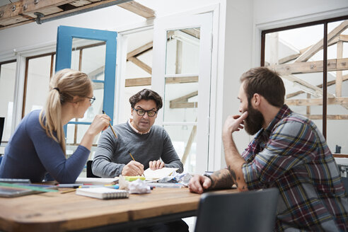 Weibliche und männliche Designer beim Brainstorming am Schreibtisch des Designstudios - CUF06929