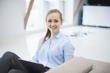 Porträt einer Designerin auf einem Sofa im Designstudio - CUF06940