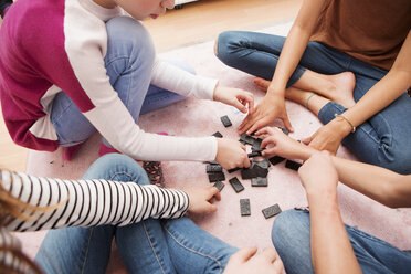 Mädchen sitzen auf dem Boden und spielen Domino - CUF07036