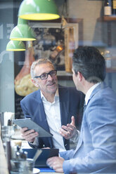 Zwei Geschäftsleute diskutieren auf einem Fensterplatz im Restaurant - CUF07046
