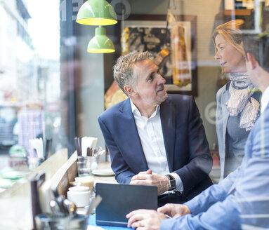 Businessmen and woman having working lunch in restaurant - CUF07048