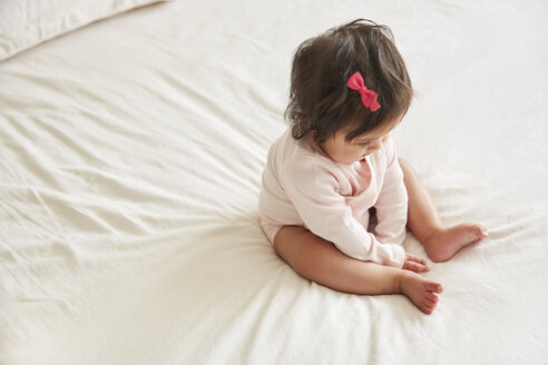 Overhead view of baby girl sitting up on bed - CUF07108