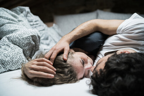 Junges Paar liegt im Bett und umarmt sich von Angesicht zu Angesicht - CUF07136