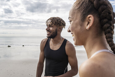 Junge Läufer und Läuferinnen lächelnd am Strand - CUF07169