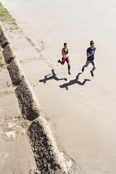 Junger Mann und Frau laufen am Strand entlang, Blick von oben - CUF07183