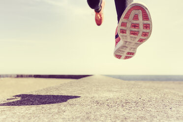 Young man running outdoors, mid air, low section - CUF07192