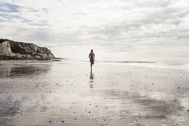 Young woman running along beach - CUF07195