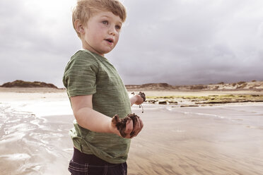 Junge am Strand, hält nassen Sand, Santa Cruz de Tenerife, Kanarische Inseln, Spanien, Europa - CUF07237