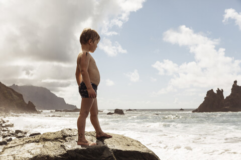 Young boy standing on rock, looking at view, Santa Cruz de Tenerife, Canary Islands, Spain, Europe stock photo