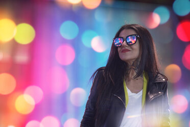 Porträt einer jungen Frau, nachts im Freien, Lichter spiegeln sich in der Brille - CUF07296