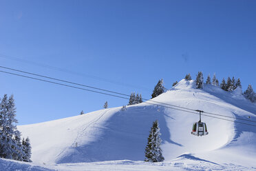 Cable car in snow covered mountain landscape, Gstaad, Switzerland - CUF07355