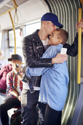 Romantisches junges Paar, das sich in der Straßenbahn umarmt - CUF07485