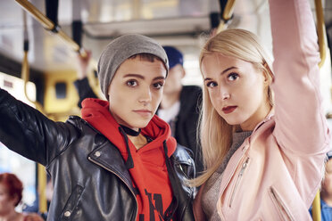 Two young women standing on city tram - CUF07486