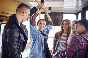 Fünf junge erwachsene Freunde unterhalten sich in der Straßenbahn - CUF07508