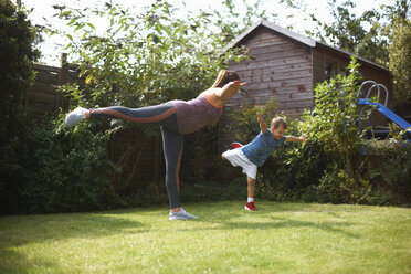 Mother and son exercising in garden, standing in yoga position - CUF07696