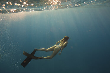 Frau mit Schwimmflossen schwimmt unter Wasser, Oahu, Hawaii, USA - ISF01458