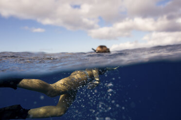 Frau mit Schwimmflossen schwimmt unter Wasser, Oahu, Hawaii, USA - ISF01460