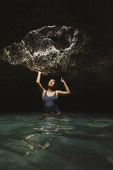 Woman in water filled cave looking up, Oahu, Hawaii, USA - ISF01463