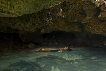 Frau schwimmt in wassergefüllter Höhle, Oahu, Hawaii, USA - ISF01465