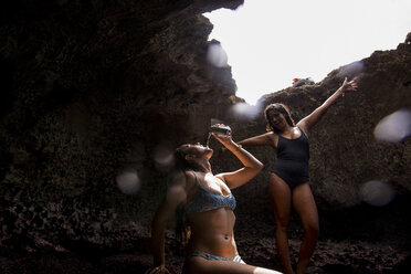 Freunde in Höhle in Badekleidung posieren, Oahu, Hawaii, USA - ISF01466
