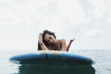 Blick von oben auf eine Frau auf einem Surfbrett, die in die Kamera schaut, Oahu, Hawaii, USA - ISF01471