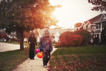 Friends dressed as witch and zombie, trick or treating in neighbourhood - ISF01475