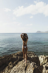 Rear view of woman wearing bikini looking at view of sea, Oahu, Hawaii, USA - ISF01493