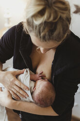 Mid adult woman breast feeding newborn baby daughter - ISF01502
