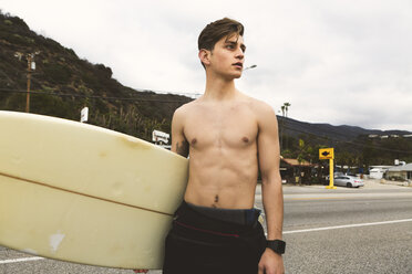 Porträt eines jungen Mannes, der ein Surfbrett hält - ISF01505