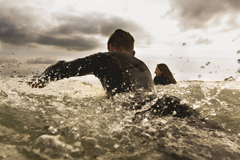 Zwei Freunde im Meer, paddelnd auf Surfbrettern, Rückansicht - ISF01510
