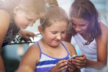 Siblings enjoying game on smartphone - ISF01553