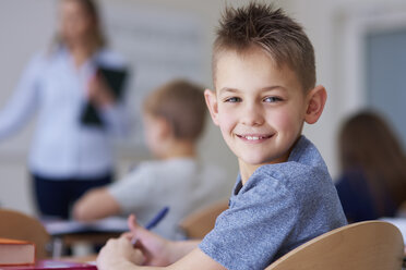 Portrait of smiling schoolboy in class - ABIF00374