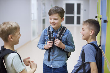 Glückliche Schüler unterhalten sich an den Schließfächern in der Schule - ABIF00385