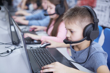 Schüler tragen Headsets und benutzen Laptops in der Schule - ABIF00387