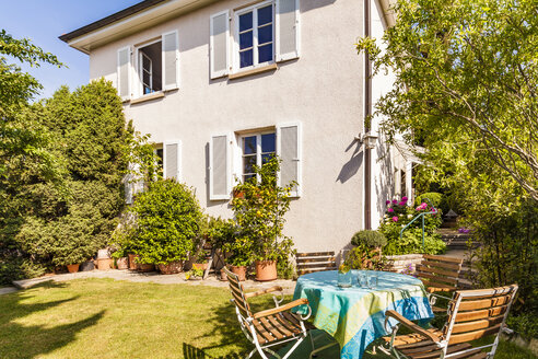 Deutschland, Stuttgart, Einfamilienhaus, Gartentisch mit Liegestühlen - WDF04658