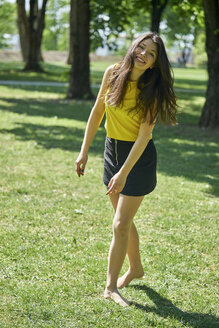 Porträt einer glücklichen jungen Frau auf einer Wiese in einem Park - BEF00060