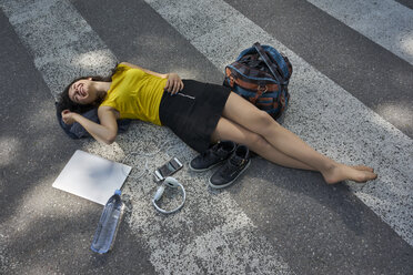 Young woman lying on zebra crossing taking a break - BEF00062