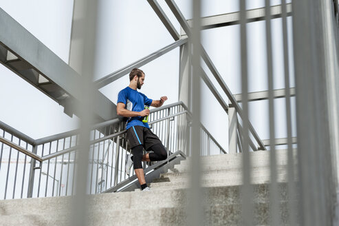 Mann auf der Treppe, der eine Pause vom Laufen macht - DIGF04246