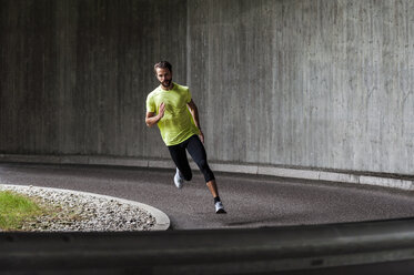 Man running on a street in a curve - DIGF04263