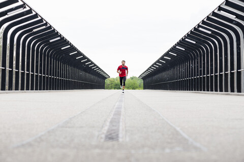 Mann läuft auf einer Brücke, lizenzfreies Stockfoto