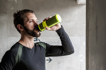 Porträt eines Sportlers, der aus einer Flasche trinkt - DIGF04293