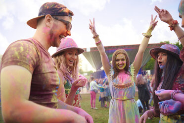 Junge erwachsene Freunde tanzen mit farbigem Kreidepulver bedeckt auf einem Festival - ISF01656